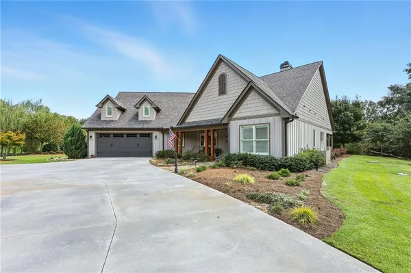 a front view of a house with a yard and potted plants