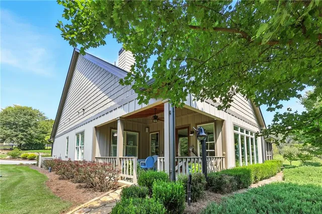 an aerial view of house with yard and trees all around