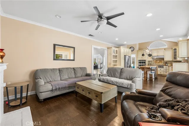 a living room with furniture kitchen view and a chandelier