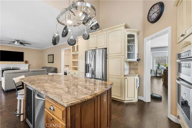 a kitchen with stainless steel appliances granite countertop a kitchen island a stove and a refrigerator