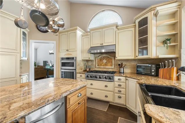 a kitchen with stainless steel appliances granite countertop a stove and cabinets