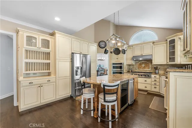 a kitchen with cabinets a sink stainless steel appliances and dining table