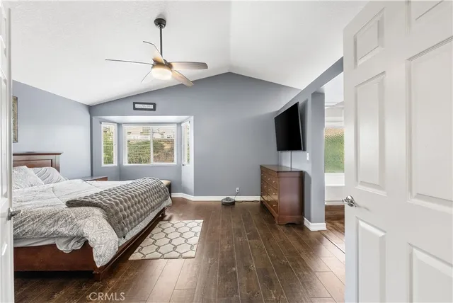 a bedroom with a bed tv and table