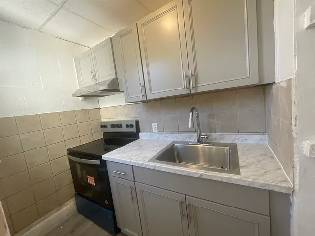 a kitchen with stainless steel appliances granite countertop a sink stove and cabinets