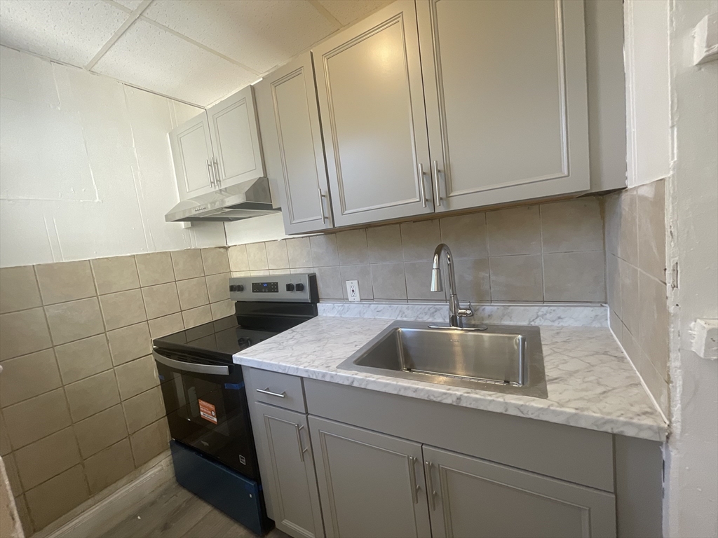 a kitchen with stainless steel appliances granite countertop a sink stove and cabinets