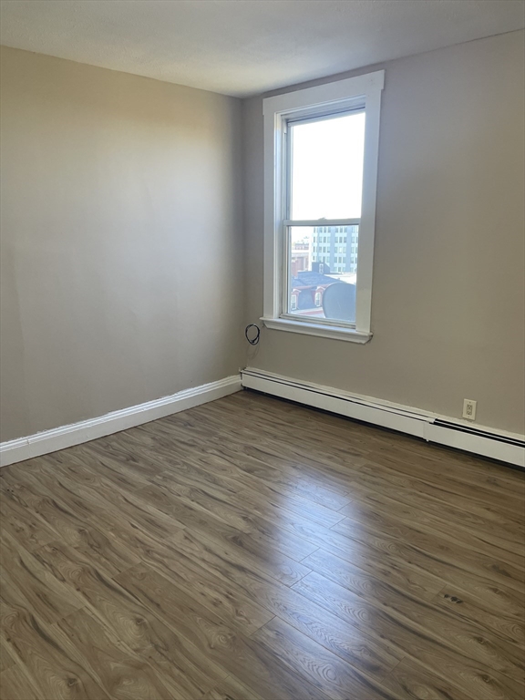 18 Lawton Avenue, Unit 3 Lynn, MA 01902 - Photo 11 of 24 a view of an empty room with wooden floor and a window