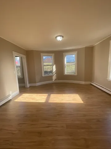 wooden floor in an empty room with a window
