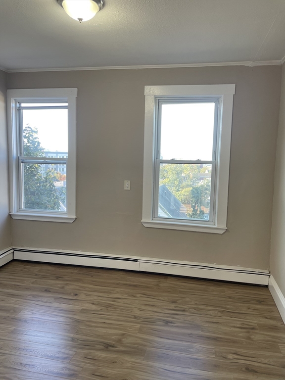 18 Lawton Avenue, Unit 3 Lynn, MA 01902 - Photo 21 of 24 a view of an empty room with wooden floor and a window