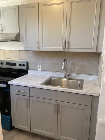 a kitchen with white cabinets and sink