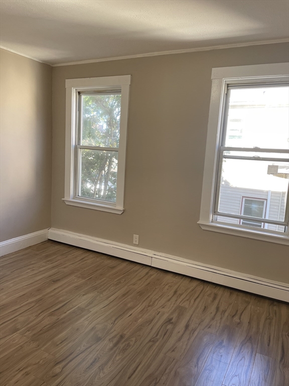18 Lawton Avenue, Unit 3 Lynn, MA 01902 - Photo 7 of 24 a view of an empty room with wooden floor and a window