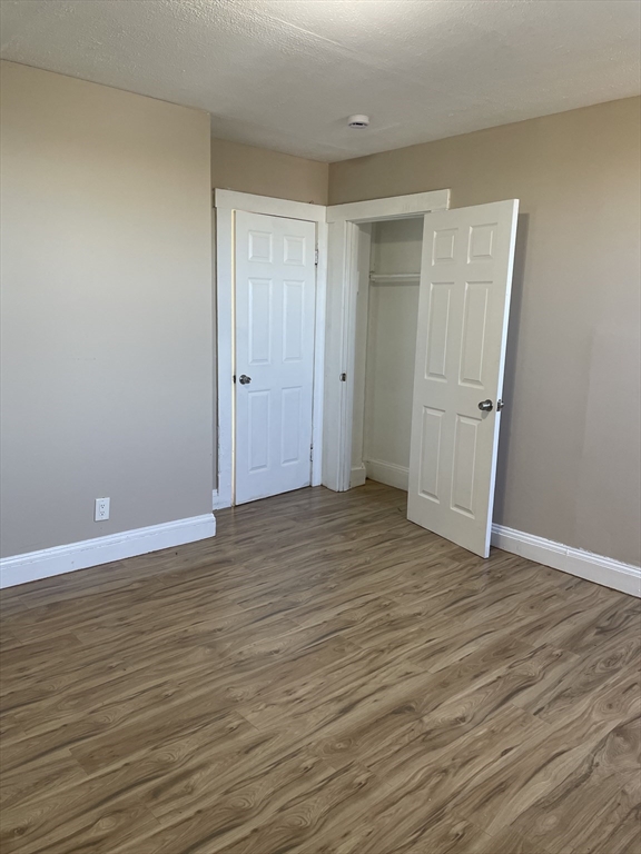 18 Lawton Avenue, Unit 3 Lynn, MA 01902 - Photo 9 of 24 a view of an empty room with wooden floor and window