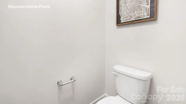 a white toilet sitting next to a white wall
