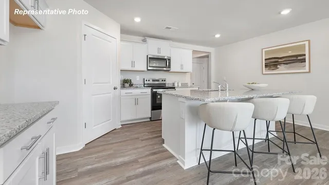 a large kitchen with stainless steel appliances granite countertop a stove a sink a dining table and chairs