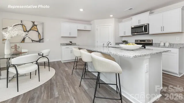 a kitchen with granite countertop white cabinets and stainless steel appliances