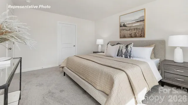 a bedroom with a bed and a lamp on dresser
