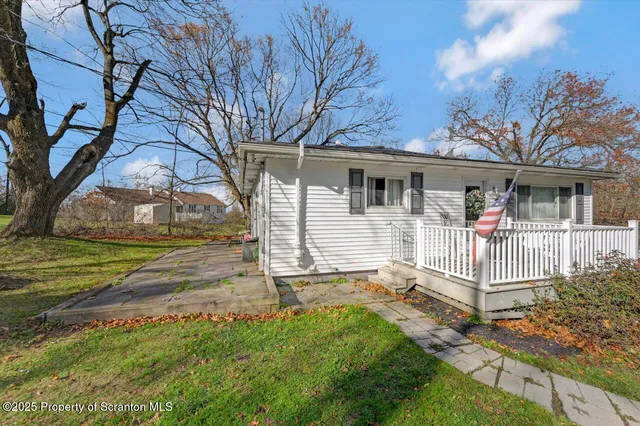 a view of a house with a yard and tree s