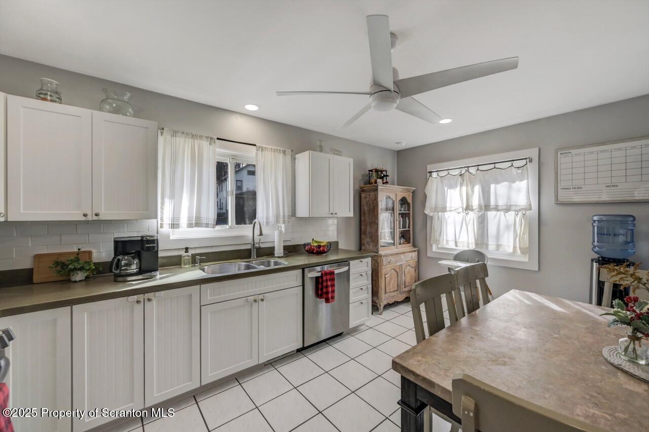 101 Miller Road Clarks Summit, PA 18411 - Photo 9 of 51 a kitchen with a stove a sink dishwasher a dining table and chairs with wooden floor