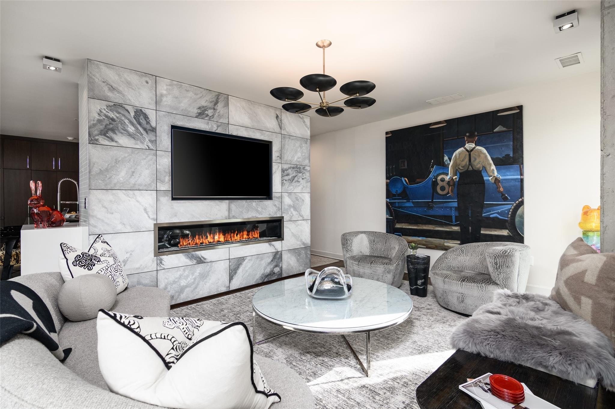 a living room with furniture a flat screen tv and a chandelier