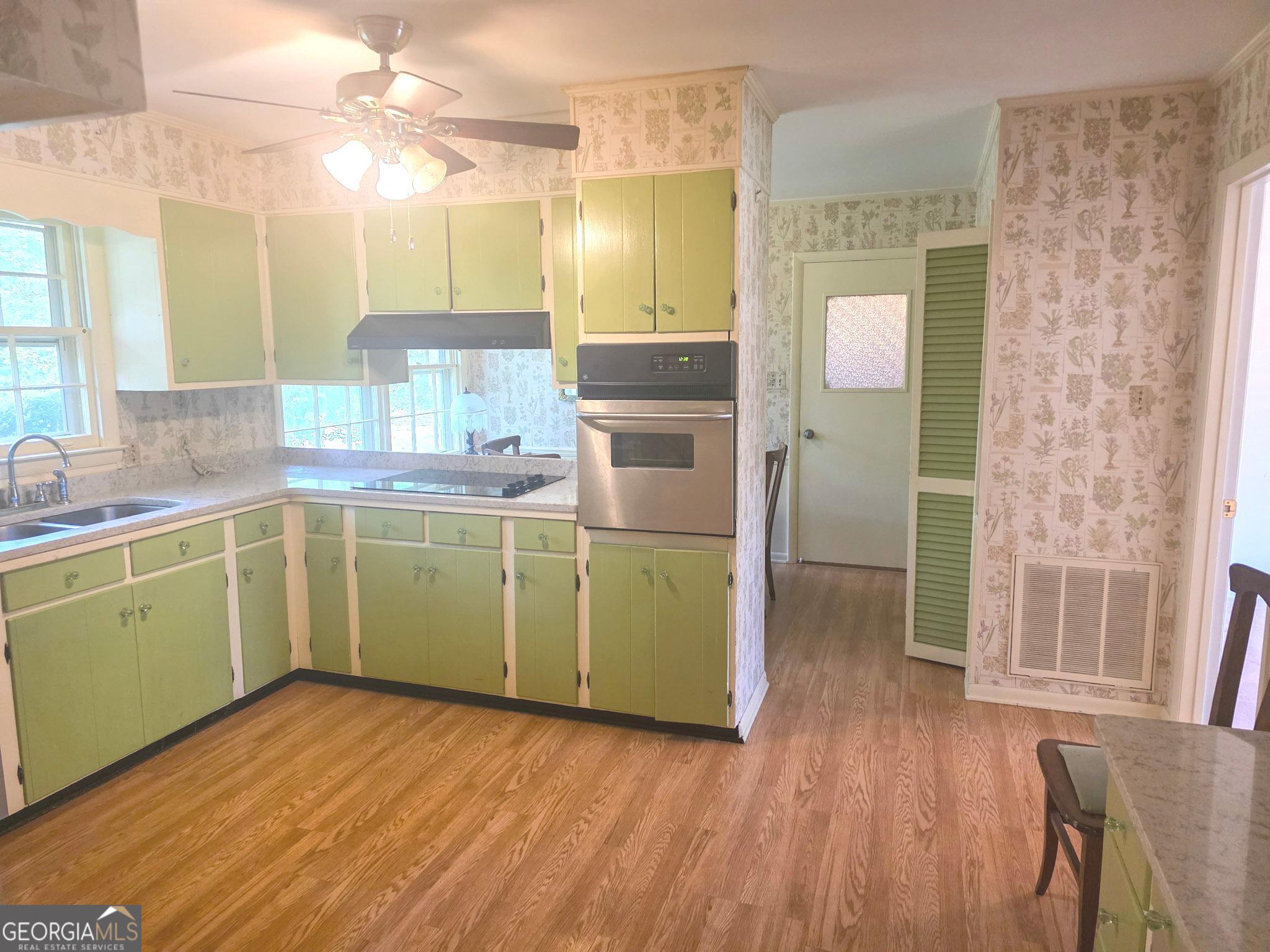 1712 Briarcliff Road Milledgeville, GA 31061 - Photo 14 of 44 a kitchen with a wooden floor cabinets and a sink