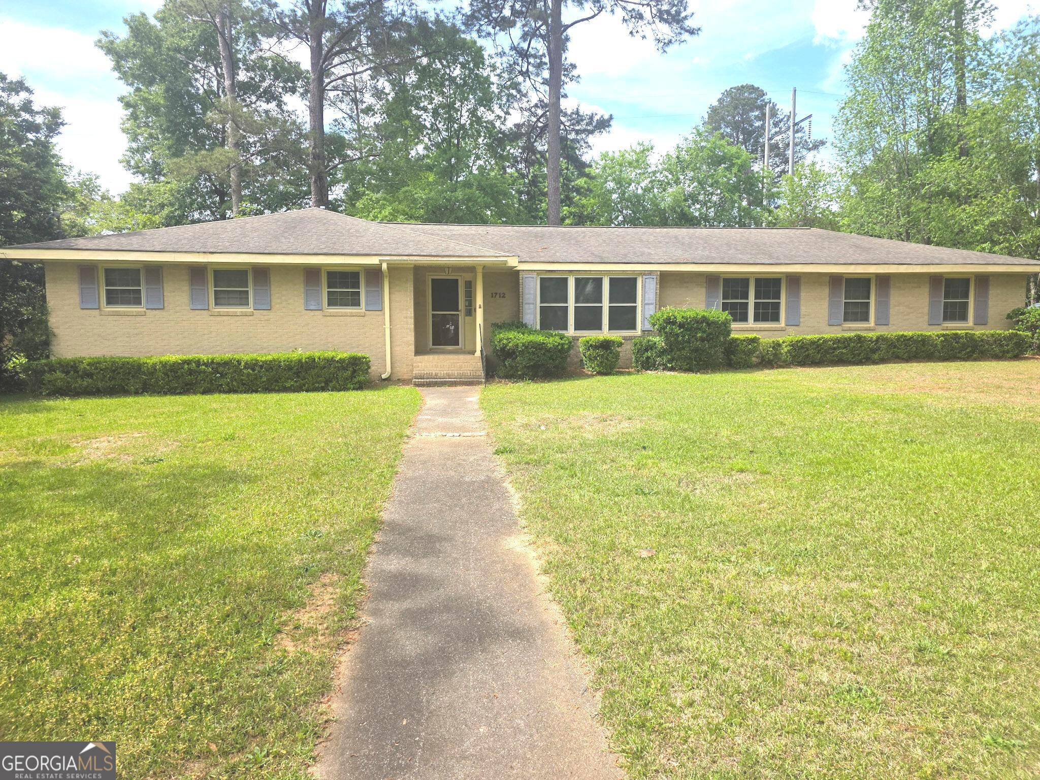 1712 Briarcliff Road Milledgeville, GA 31061 - Photo 4 of 44 a front view of a house with a yard and trees