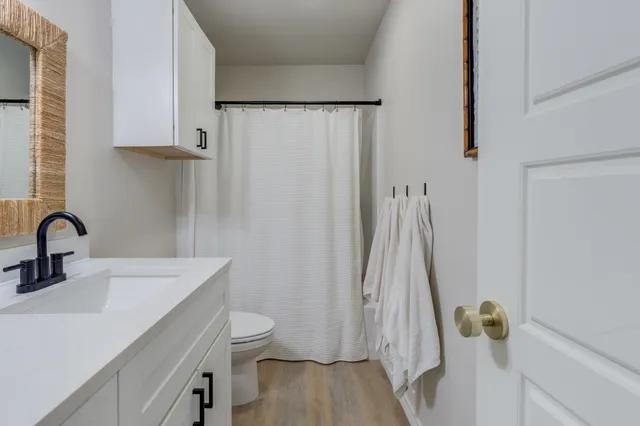 a bathroom with a sink a toilet and shower