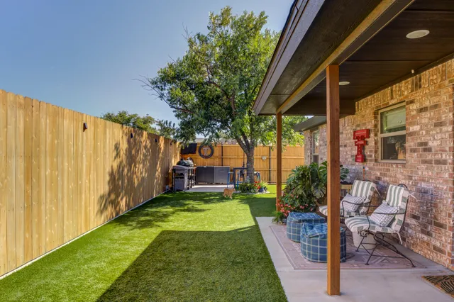 a view of swimming pool with garden and patio