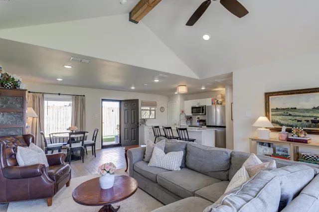 a living room with furniture and kitchen view