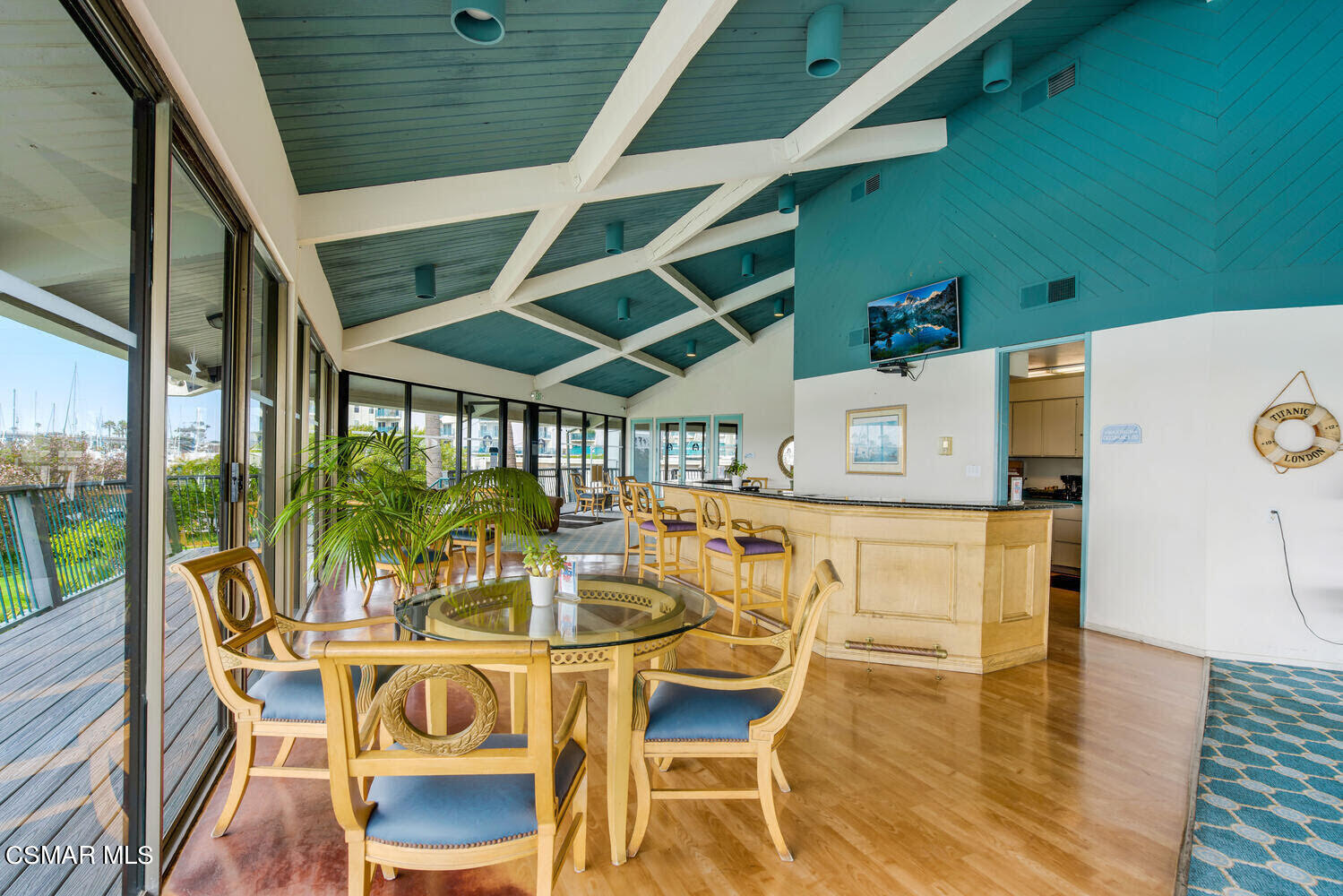 2901 Peninsula Road, Unit 137 Oxnard, CA 93035 - Photo 24 of 36 a view of a patio with table and chairs with wooden floor and fence