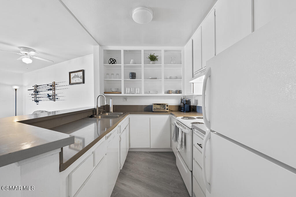 2901 Peninsula Road, Unit 137 Oxnard, CA 93035 - Photo 9 of 36 a kitchen with stainless steel appliances granite countertop a sink and dishwasher a stove with wooden floor