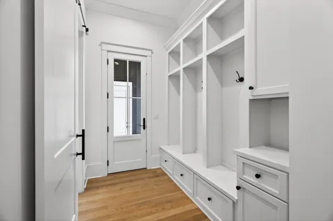 a view of empty room with wooden floor and window