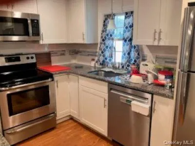 a kitchen with stainless steel appliances granite countertop a sink stove and microwave