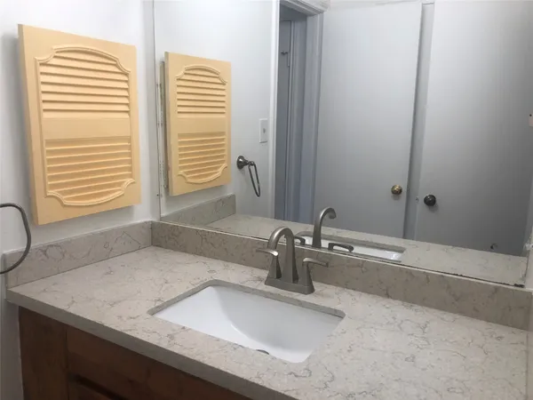 a bathroom with a granite countertop sink and a mirror
