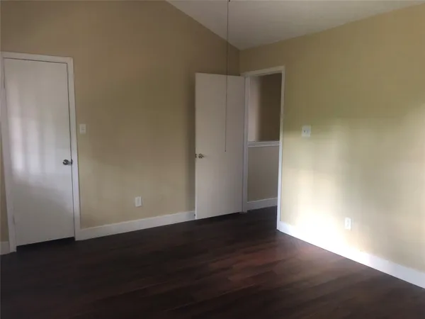 an empty room with wooden floor and closet