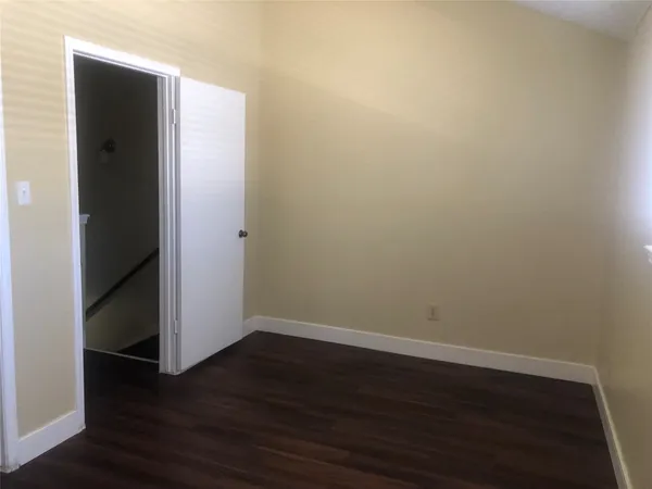 an empty room with wooden floor and closet