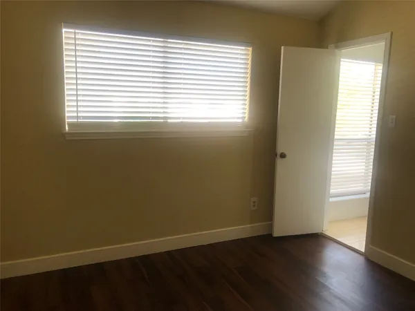 an empty room with wooden floor and a window