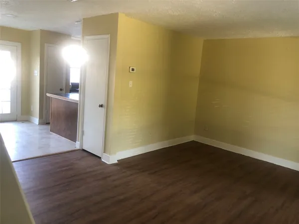 a view of a room with wooden floor and a window