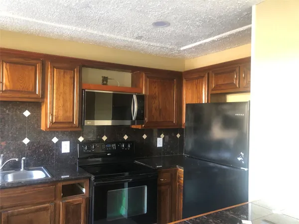 a kitchen with a refrigerator and a stove
