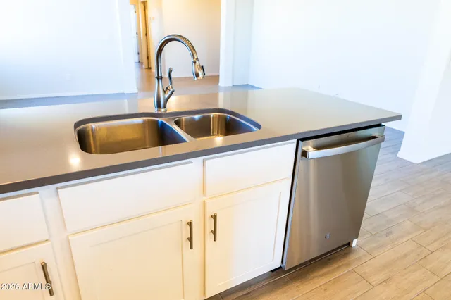 a large kitchen with granite countertop a large counter top stainless steel appliances and cabinets