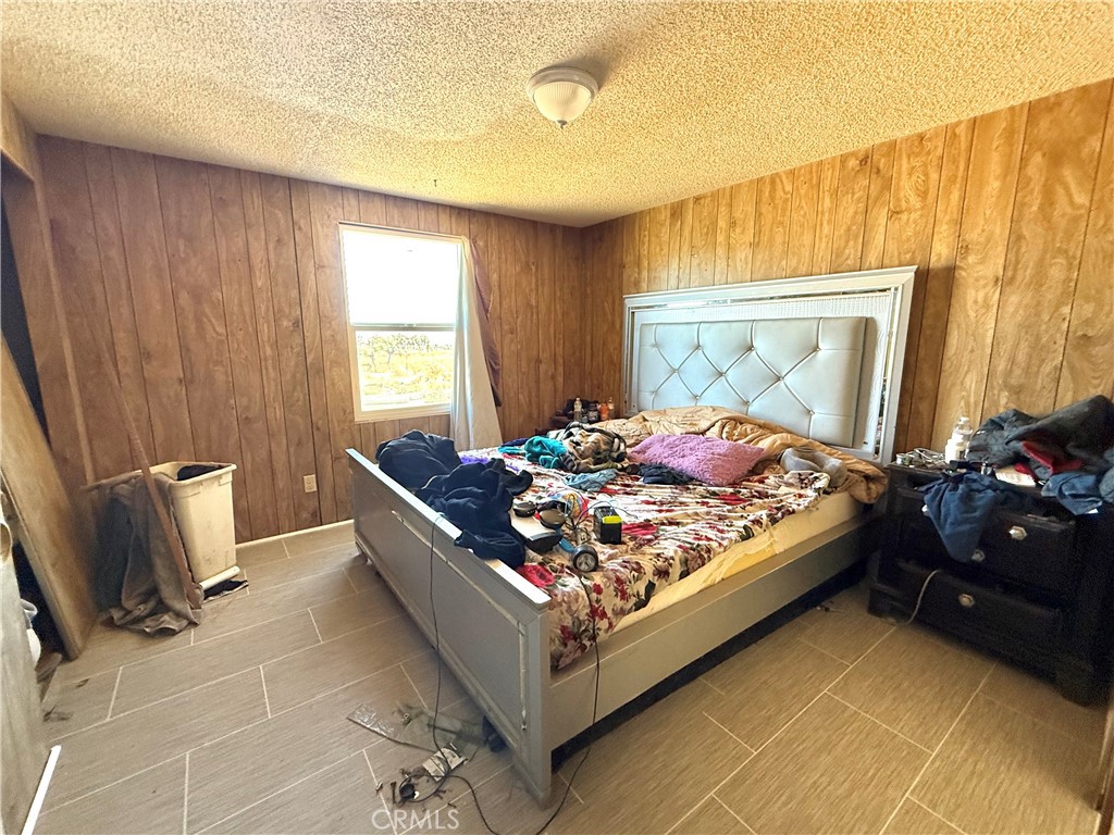 9589 Paramount Road Phelan, CA 92371 - Photo 24 of 29 a bed sitting in a bedroom next to a window and dresser