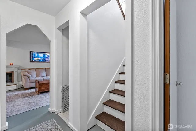 a view of a hallway to of bedroom with stairs and furniture