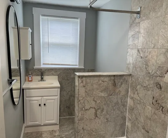 a bathroom with a sink a mirror and shower