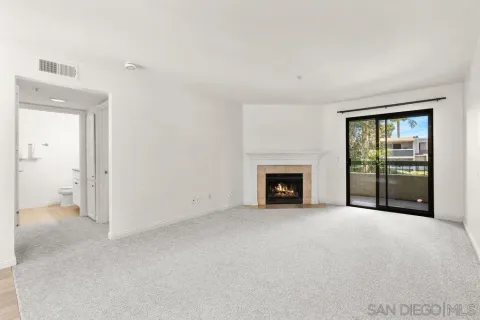 an empty room with floor to ceiling window and fireplace