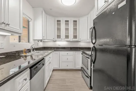 a kitchen with granite countertop a sink and stainless steel appliances