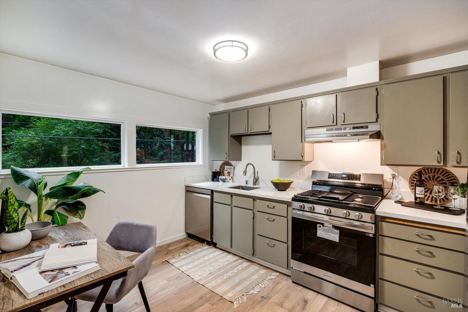 15300 Canyon 3 Road Guerneville, CA 95446 - Photo 4 of 37 a kitchen with stainless steel appliances a stove a sink cabinets and a window
