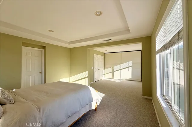 a bedroom with a bed and a large window