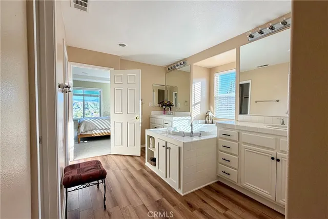 a en suite bathroom with a granite countertop sink and a mirror