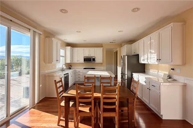 a kitchen with a table chairs refrigerator and microwave