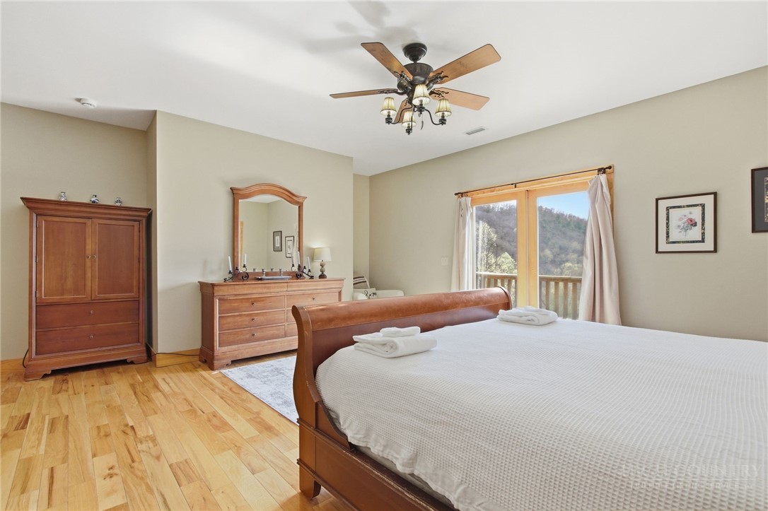 2081 Blackberry Road Boone, NC 28607 - Photo 29 of 45 a bedroom with a large bed a chandelier and dresser