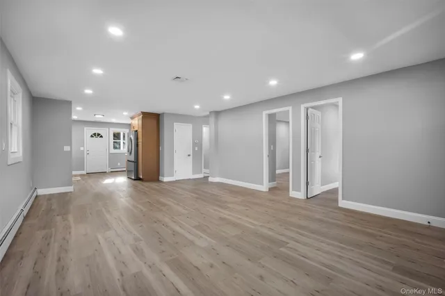 a view of an empty room with wooden floor