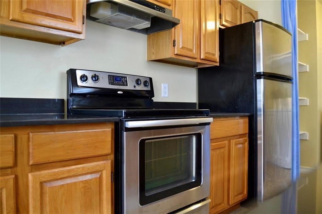 a kitchen with stainless steel appliances granite countertop cabinets and a refrigerator
